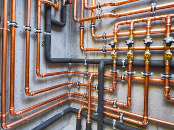 View of a plumbing system showcasing piping infrastructure attached to a cement wall